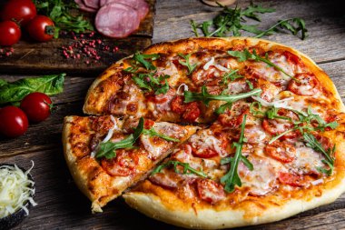 Ahşap arka planda jambonlu iştah açıcı pizza.