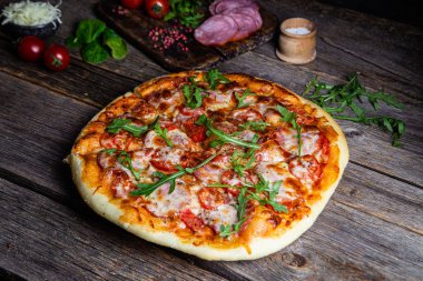 Ahşap arka planda jambonlu iştah açıcı pizza.