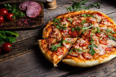 Ahşap arka planda jambonlu iştah açıcı pizza.