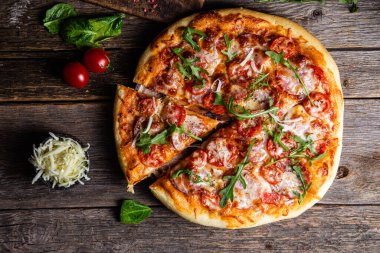 Ahşap arka planda jambonlu iştah açıcı pizza.