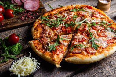 Ahşap arka planda jambonlu iştah açıcı pizza.