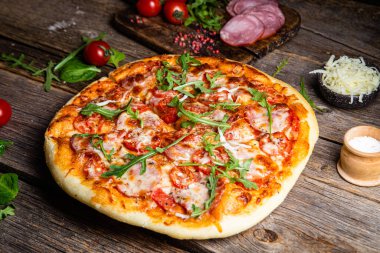Ahşap arka planda jambonlu iştah açıcı pizza.