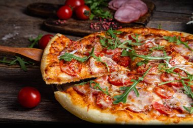 Ahşap arka planda jambonlu iştah açıcı pizza.