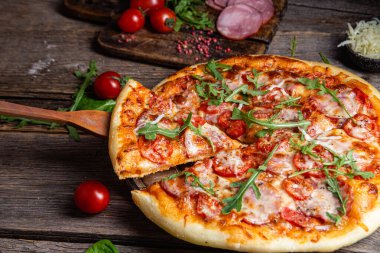 Ahşap arka planda jambonlu iştah açıcı pizza.