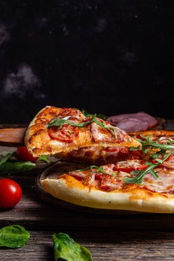 Ahşap arka planda jambonlu iştah açıcı pizza.