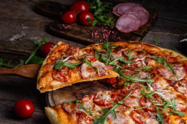 Ahşap arka planda jambonlu iştah açıcı pizza.