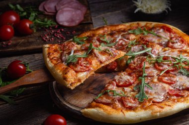 Ahşap arka planda jambonlu iştah açıcı pizza.