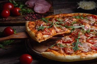 Ahşap arka planda jambonlu iştah açıcı pizza.