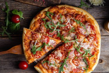 Ahşap arka planda jambonlu iştah açıcı pizza.