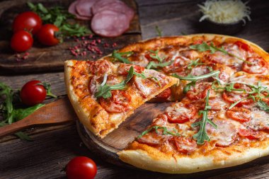 Ahşap arka planda jambonlu iştah açıcı pizza.
