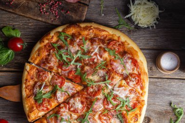 Ahşap arka planda jambonlu iştah açıcı pizza.