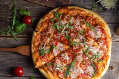 Ahşap arka planda jambonlu iştah açıcı pizza.