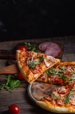 Ahşap arka planda jambonlu iştah açıcı pizza.