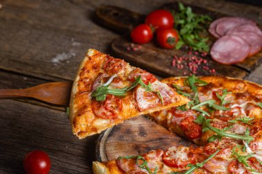 Ahşap arka planda jambonlu iştah açıcı pizza.