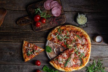 Ahşap arka planda jambonlu iştah açıcı pizza.