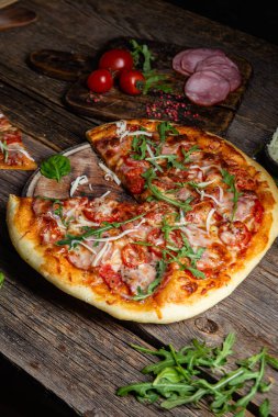 Ahşap arka planda jambonlu iştah açıcı pizza.