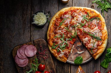 Ahşap arka planda jambonlu iştah açıcı pizza.