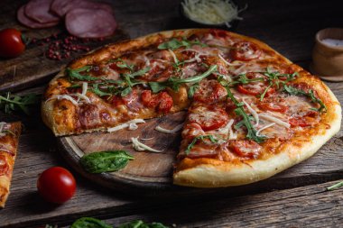 Ahşap arka planda jambonlu iştah açıcı pizza.