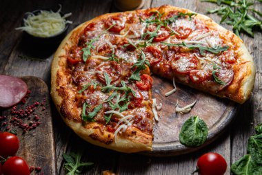 Ahşap arka planda jambonlu iştah açıcı pizza.