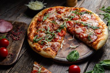 Ahşap arka planda jambonlu iştah açıcı pizza.