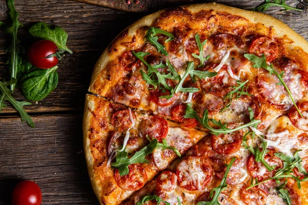 Ahşap arka planda jambonlu iştah açıcı pizza.