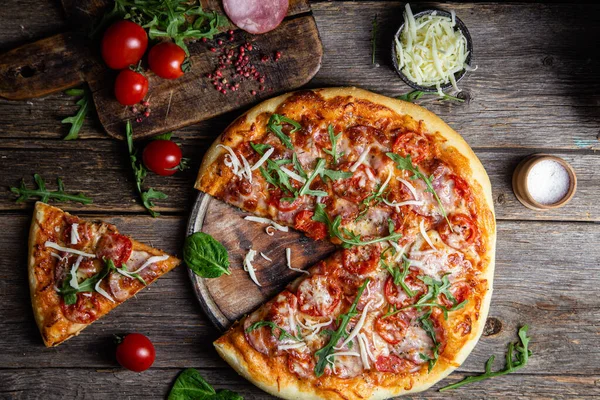 Ahşap arka planda jambonlu iştah açıcı pizza.