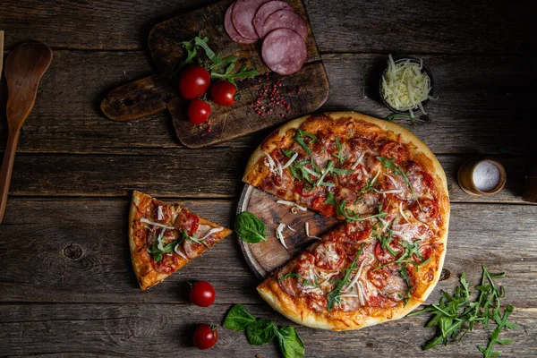 Ahşap arka planda jambonlu iştah açıcı pizza.