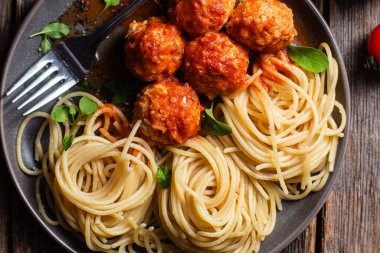 Köfteli makarna ve ahşap bir masada bir tabakta sos.