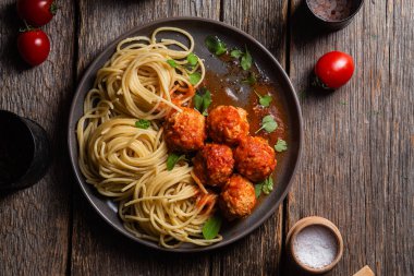 Köfteli makarna ve ahşap bir masada bir tabakta sos.