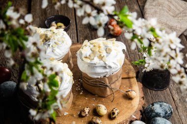 Ahşap arka planda kremalı ve badem yapraklı Paskalya keki.