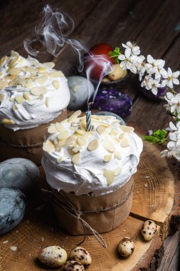 Ahşap arka planda kremalı ve badem yapraklı Paskalya keki.