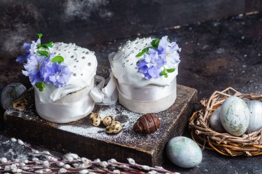 Koyu arkaplanda menekşe ve kremalı Paskalya pastası