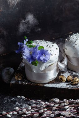 Koyu arkaplanda menekşe ve kremalı Paskalya pastası