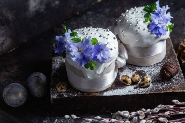 Koyu arkaplanda menekşe ve kremalı Paskalya pastası