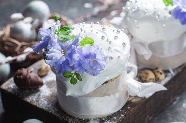 Koyu arkaplanda menekşe ve kremalı Paskalya pastası