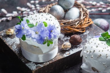 Koyu arkaplanda menekşe ve kremalı Paskalya pastası