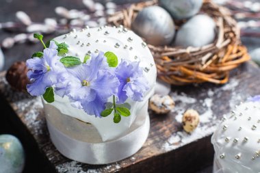 Koyu arkaplanda menekşe ve kremalı Paskalya pastası