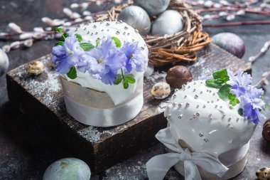 Koyu arkaplanda menekşe ve kremalı Paskalya pastası