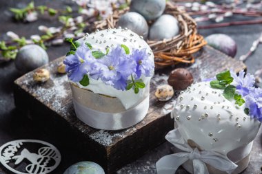 Koyu arkaplanda menekşe ve kremalı Paskalya pastası