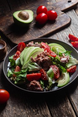 Ton balıklı salata, avokado ve domatesler kasede.