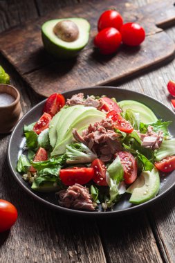 Ton balıklı salata, avokado ve domatesler kasede.