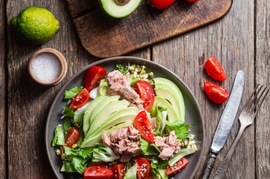 Ton balıklı salata, avokado ve domatesler kasede.