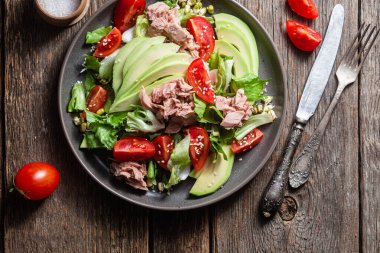 Ton balıklı salata, avokado ve domatesler kasede.