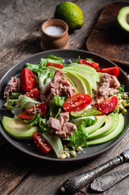 Ton balıklı salata, avokado ve domatesler kasede.