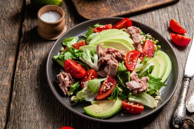 Ton balıklı salata, avokado ve domatesler kasede.