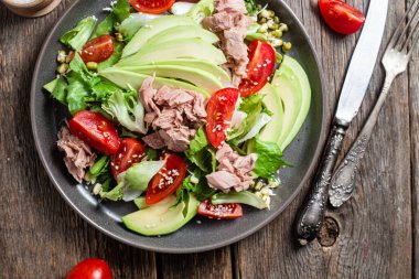 Ton balıklı salata, avokado ve domatesler kasede.