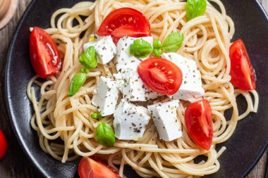 Tabakta peynirli ve domatesli spagetti. İtalyan makarnası