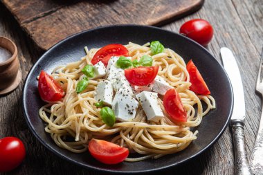 Tabakta peynirli ve domatesli spagetti. İtalyan makarnası