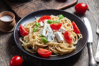 Tabakta peynirli ve domatesli spagetti. İtalyan makarnası