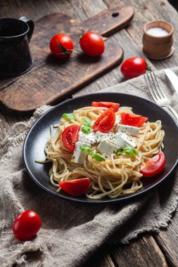 Tabakta peynirli ve domatesli spagetti. İtalyan makarnası